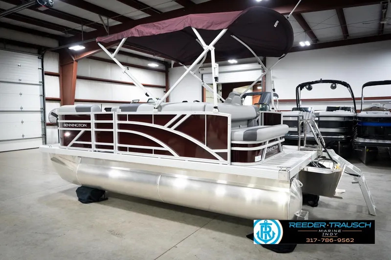 Slide: The Image of 2026 Bennington 168 SLJ pontoon boat in showroom with maroon canopy. - 10