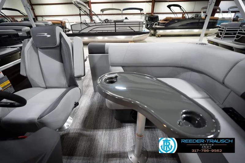 Slide: The Image of 2026 Bennington 168 SLJ pontoon boat interior with seating and table in showroom. - 17