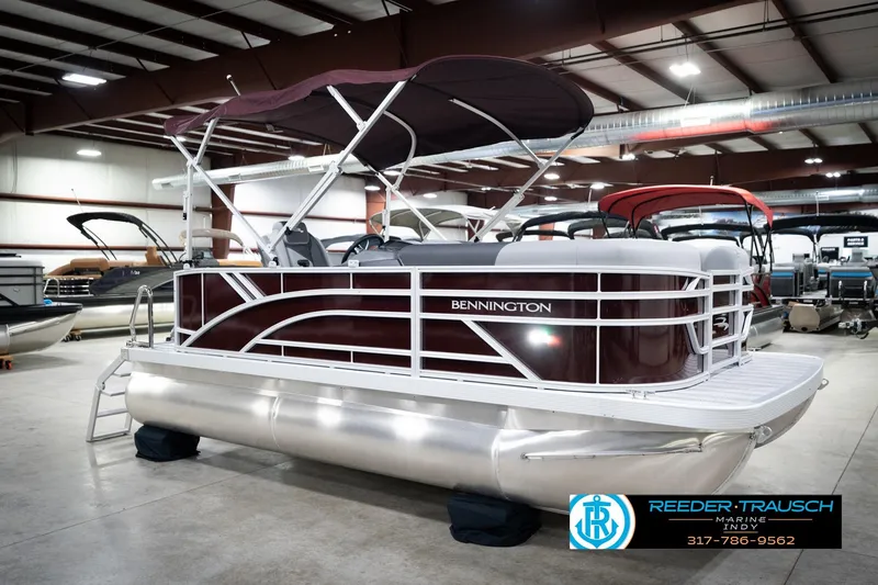 Slide: The Image of 2026 Bennington 168 SLJ pontoon boat in showroom, featuring sleek design and maroon accents. - 6