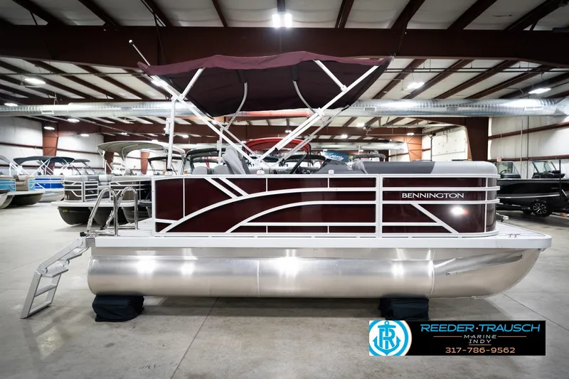 Slide: The Image of 2026 Bennington 168 SLJ pontoon boat in showroom, featuring sleek design and maroon accents. - 7