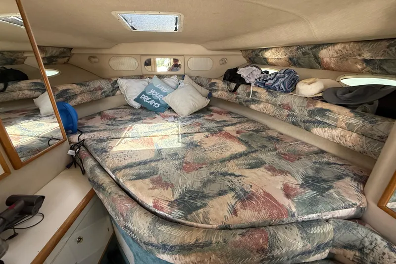Slide: The Image of Cozy cabin interior of 1995 Sea Ray 330 Sundancer with patterned bedding and pillows. - 12