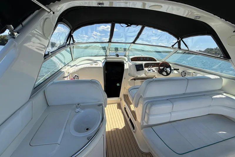 Slide: The Image of Interior of 1995 Sea Ray 330 Sundancer boat with white seating and wooden flooring. - 14