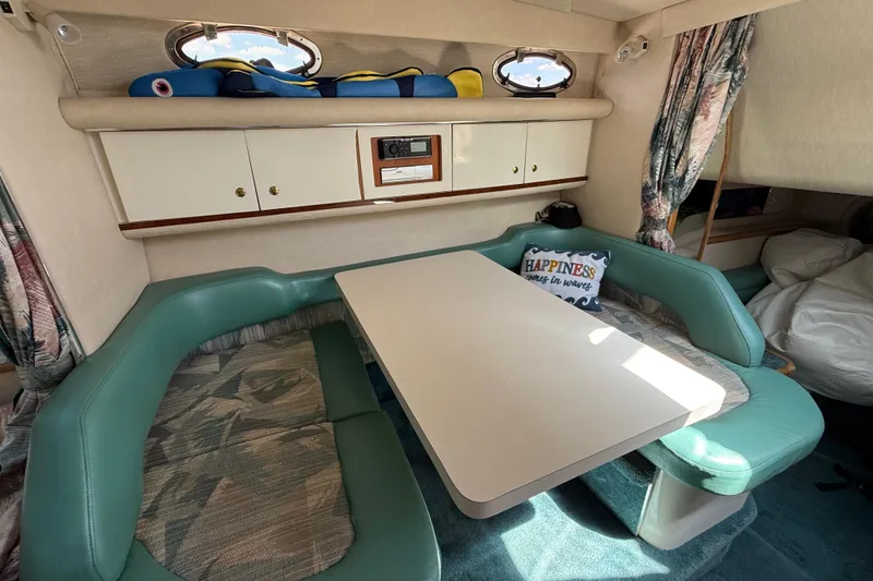 Slide: The Image of 1995 Sea Ray 330 Sundancer cabin with teal seating and dining table. - 16