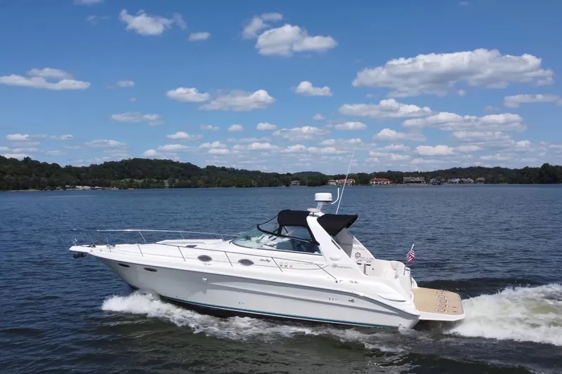 Slide: The Image of 1995 Sea Ray 330 Sundancer cruising on a lake under a clear blue sky. - 3