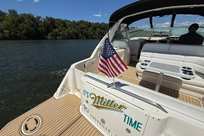 Slide: The Image of 1995 Sea Ray 330 Sundancer boat with American flag on a scenic river cruise. - 7