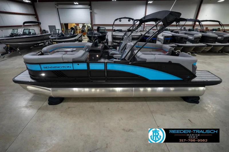 Slide: The Image of 2026 Bennington 22 MFB pontoon boat in showroom with blue and black design. - 2