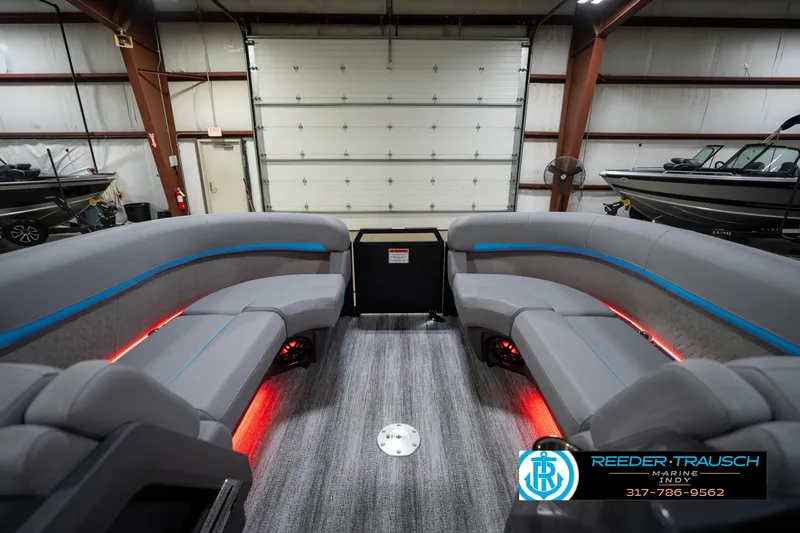 Slide: The Image of 2026 Bennington 22 MFB boat interior with gray seating, blue accents, and ambient red lighting. - 22