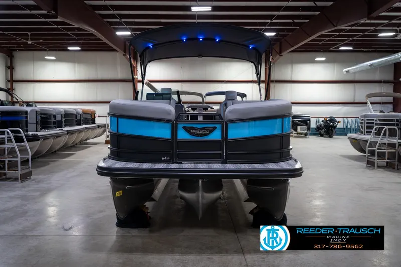 Slide: The Image of 2026 Bennington 22 MFB pontoon boat in showroom, featuring sleek design and blue accents. - 5