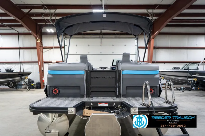 Slide: The Image of 2026 Bennington 22 MFB pontoon boat in indoor showroom with ladder and seating. - 62