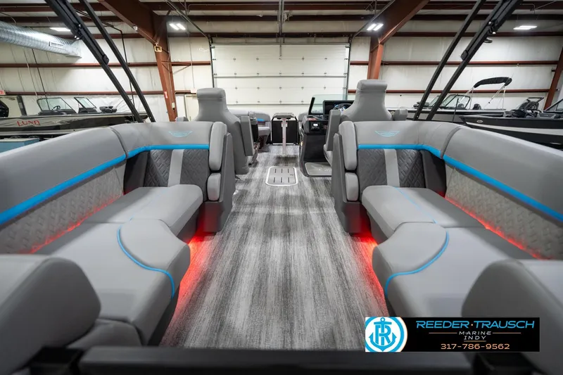 Slide: The Image of 2026 Bennington 22 MFB boat interior with gray seating, blue accents, and ambient red lighting. - 72