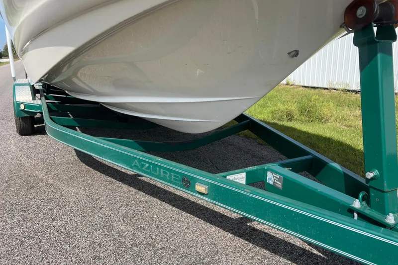 Slide: The Image of 2007 Azure AZ240 boat on green trailer, parked on asphalt road. - 14