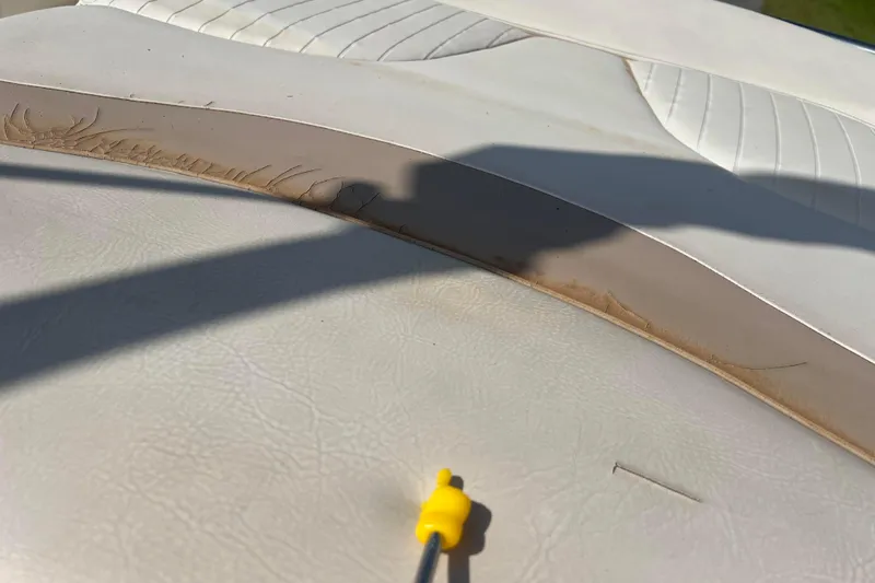 Slide: The Image of Aging white leather seat with visible cracks on a 2007 Azure AZ240. - 28