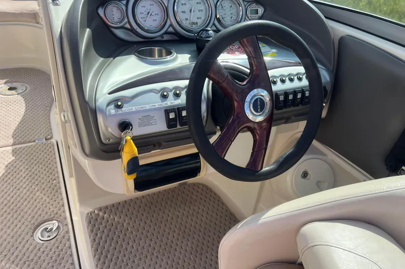 Slide: The Image of Steering wheel and dashboard of 2007 Azure AZ240 boat, featuring gauges and controls. - 37
