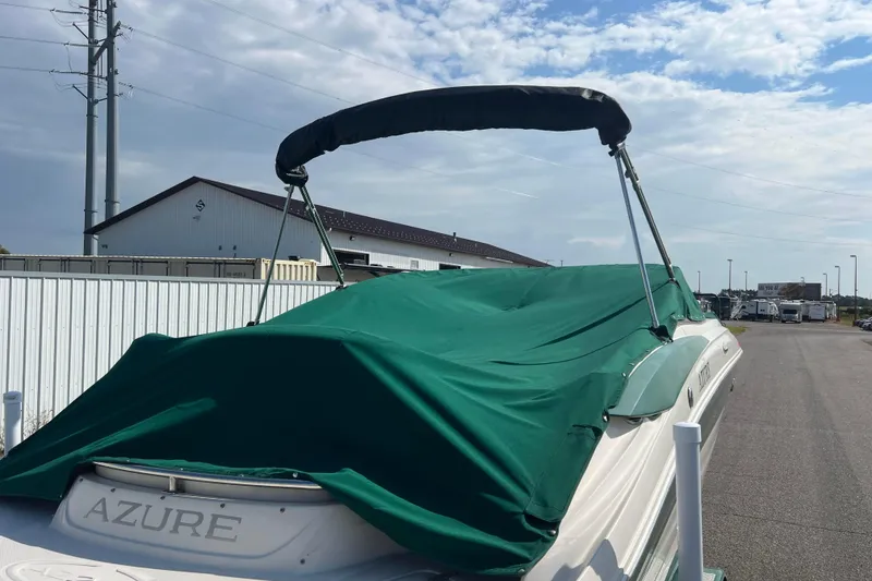 Slide: The Image of Covered 2007 Azure AZ240 boat parked outdoors under a partly cloudy sky. - 5