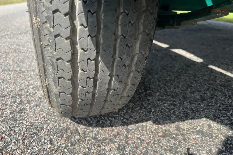 Slide: The Image of Close-up of a worn tire on a 2007 Azure AZ240 vehicle on asphalt road. - 61