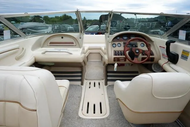 Slide: The Image of 1995 Sea Ray 200 Select boat interior with beige seating and wooden steering wheel. - 11
