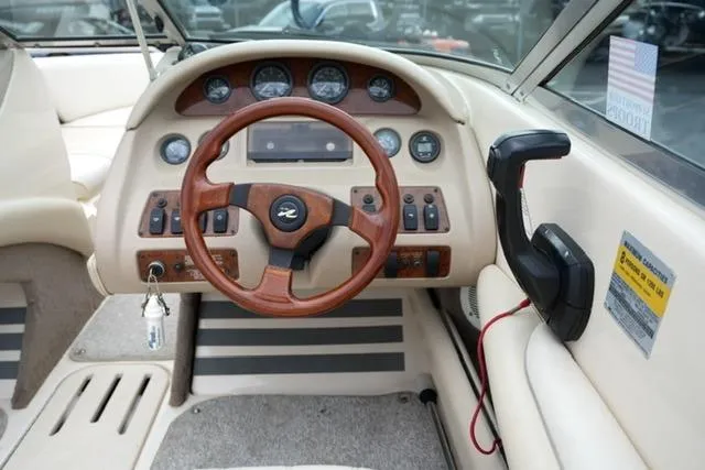 Slide: The Image of 1995 Sea Ray 200 Select boat dashboard with wood steering wheel and control panel. - 13