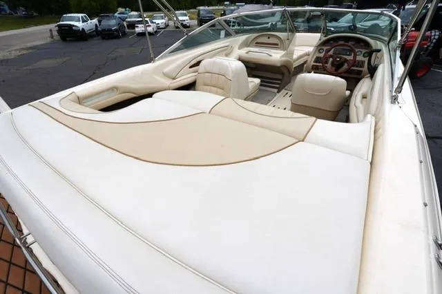 Slide: The Image of 1995 Sea Ray 200 Select boat interior with beige seating and dashboard, parked outdoors. - 16