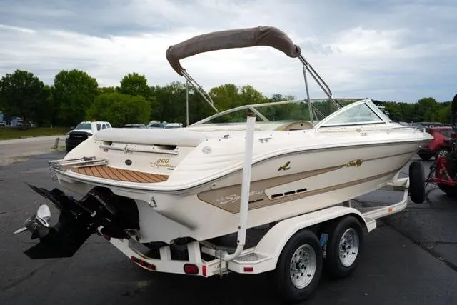 Slide: The Image of 1995 Sea Ray 200 Select boat on trailer, parked outdoors, with overcast sky. - 4