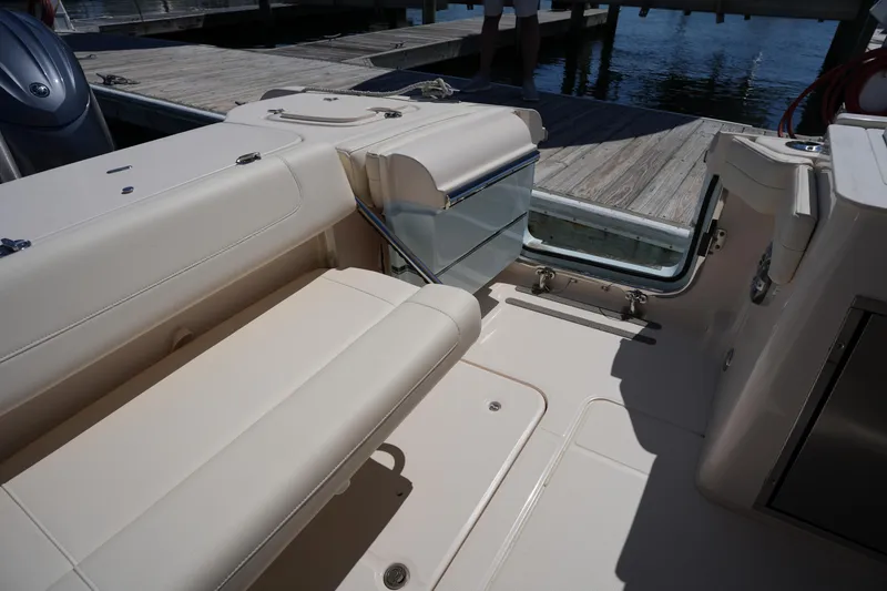 Slide: The Image of 2023 Grady-White Freedom 285 boat interior with beige seating and dock view. - 25
