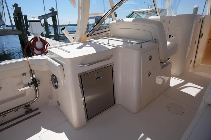 Slide: The Image of 2023 Grady-White Freedom 285 boat interior with seating and storage, docked by the water. - 26
