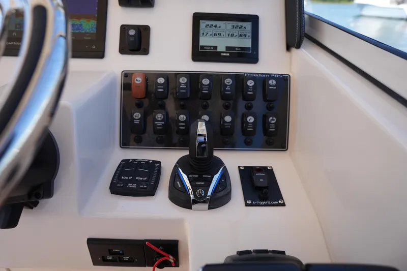 Slide: The Image of Control panel of 2023 Grady-White Freedom 285 boat with various switches and displays. - 39