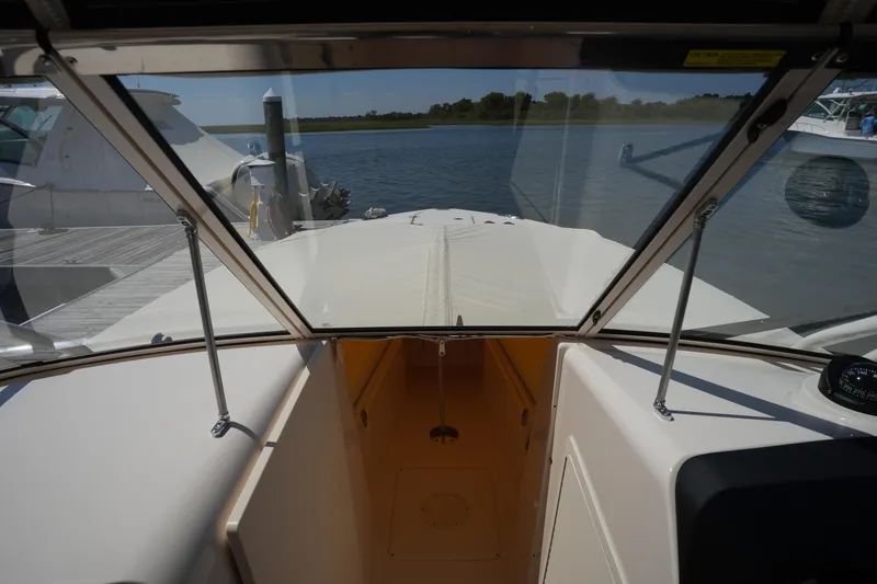 Slide: The Image of 2023 Grady-White Freedom 285 boat interior view with windshield and docked marina. - 43