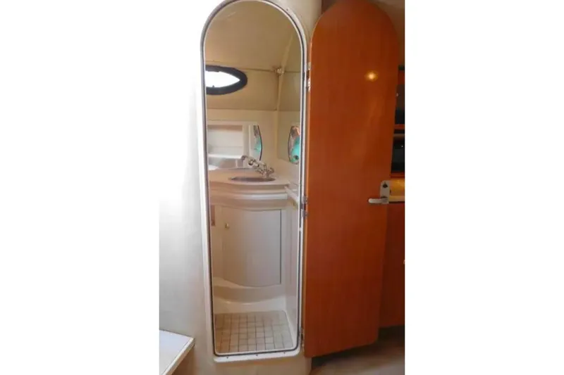 Slide: The Image of Interior of 2001 Regal Commodore 2960 boat, featuring a compact bathroom with mirror. - 14