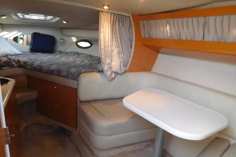 Slide: The Image of Interior of 2001 Regal Commodore 2960 boat, featuring cozy seating and sleeping area. - 7