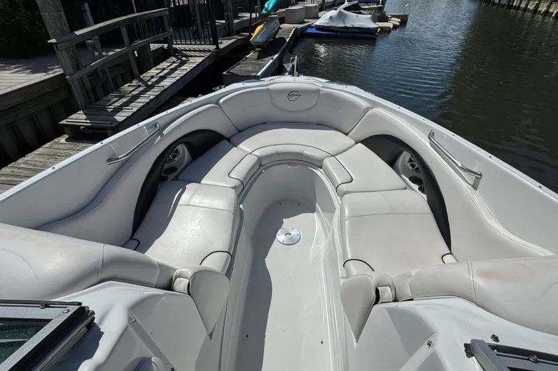 Slide: The Image of 2012 Crownline 305 SS boat with spacious white seating, docked by the water. - 14