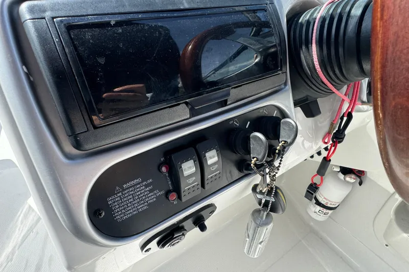 Slide: The Image of 2012 Crownline 305 SS boat dashboard with controls and keys. - 23