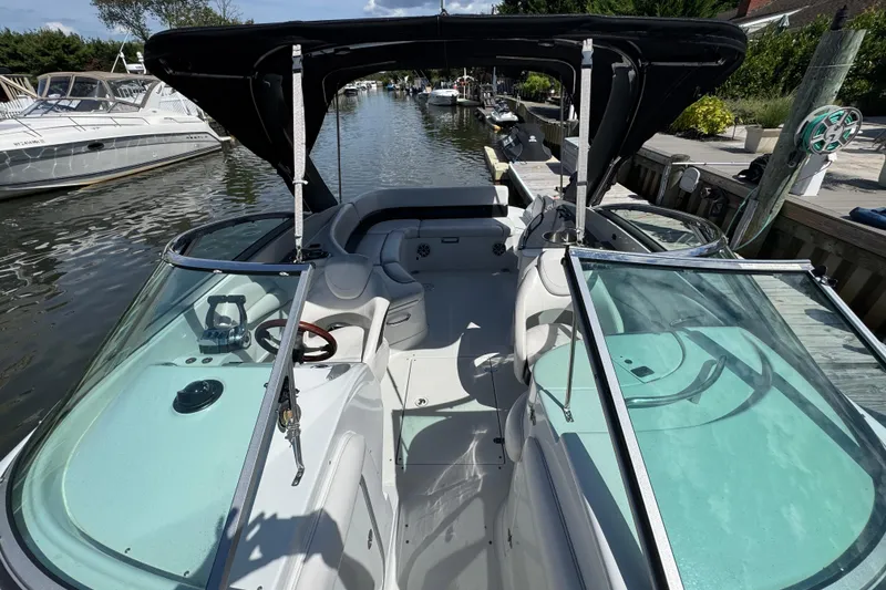 Slide: The Image of 2012 Crownline 305 SS boat interior with sleek design, docked in a serene marina. - 28