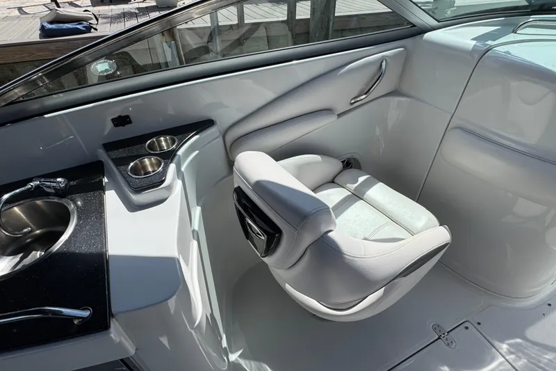 Slide: The Image of 2012 Crownline 305 SS boat interior with white seating, sink, and cup holders. - 7