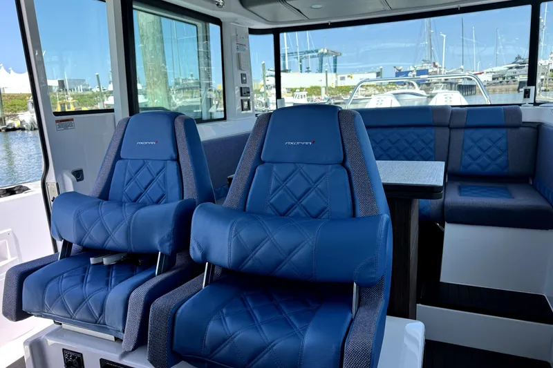 Slide: The Image of Interior of 2024 Axopar 37 XC CROSS CABIN with blue seating and table. - 12