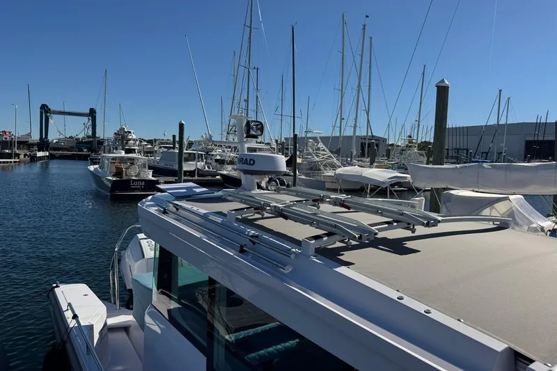 Slide: The Image of 2024 Axopar 37 XC CROSS CABIN docked in a marina with sailboats. - 16