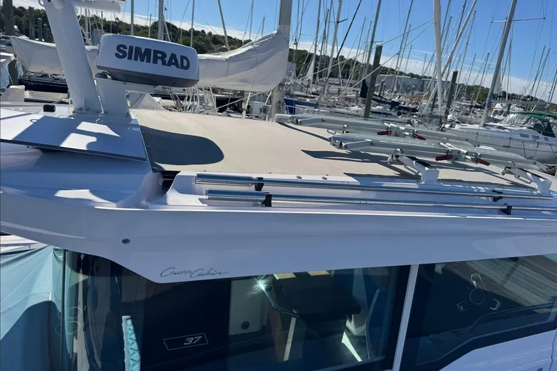 Slide: The Image of 2024 Axopar 37 XC CROSS CABIN boat with Simrad equipment in a marina setting. - 17