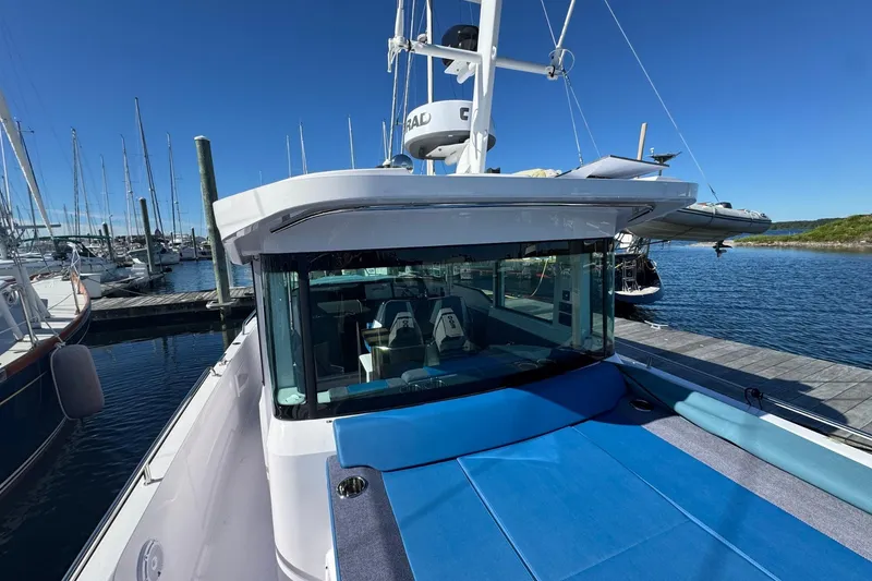 Slide: The Image of 2024 Axopar 37 XC CROSS CABIN docked at marina under clear blue sky. - 4
