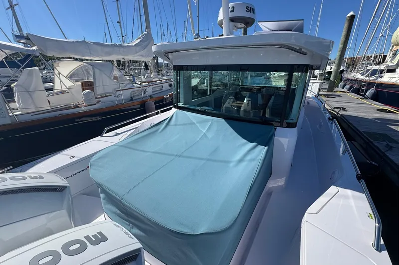 Slide: The Image of 2024 Axopar 37 XC CROSS CABIN boat docked, featuring a covered front deck. - 5