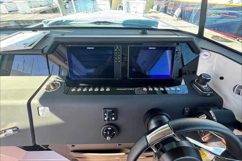 Slide: The Image of 2024 Axopar 37 XC CROSS CABIN dashboard with dual Simrad displays and steering wheel. - 7
