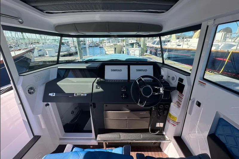 Slide: The Image of 2024 Axopar 37 XC CROSS CABIN helm with Simrad displays, docked at marina. - 9
