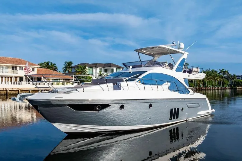 The Image of Luxury 2015 Azimut Fly 50 yacht on serene waterfront, clear blue sky backdrop. - 1