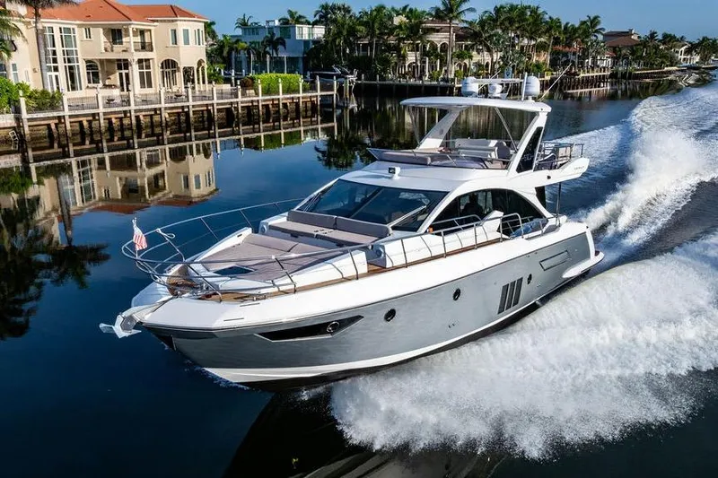 Slide: The Image of 2015 Azimut Fly 50 yacht cruising on a scenic waterway near luxury homes. - 23