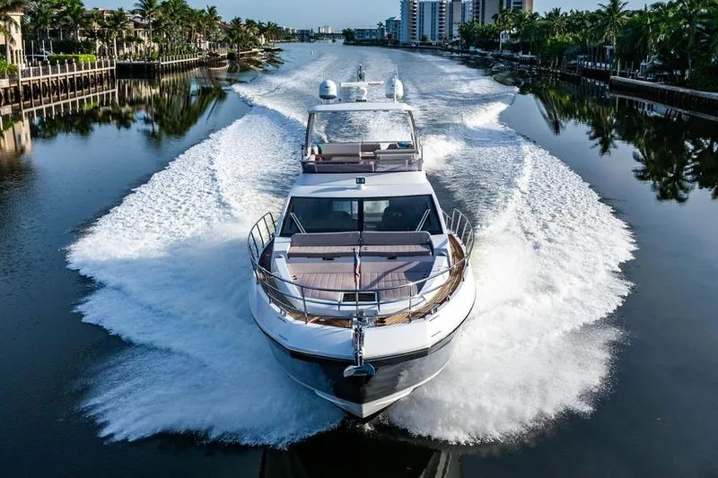 Slide: The Image of 2015 Azimut Fly 50 yacht cruising on a scenic waterway, surrounded by palm trees. - 24