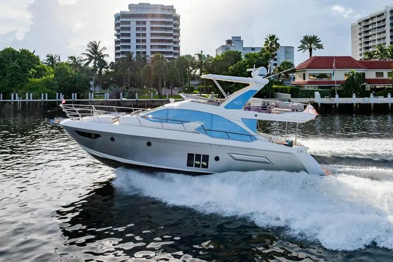 Slide: The Image of 2015 Azimut Fly 50 yacht cruising on a scenic waterfront with modern buildings. - 32