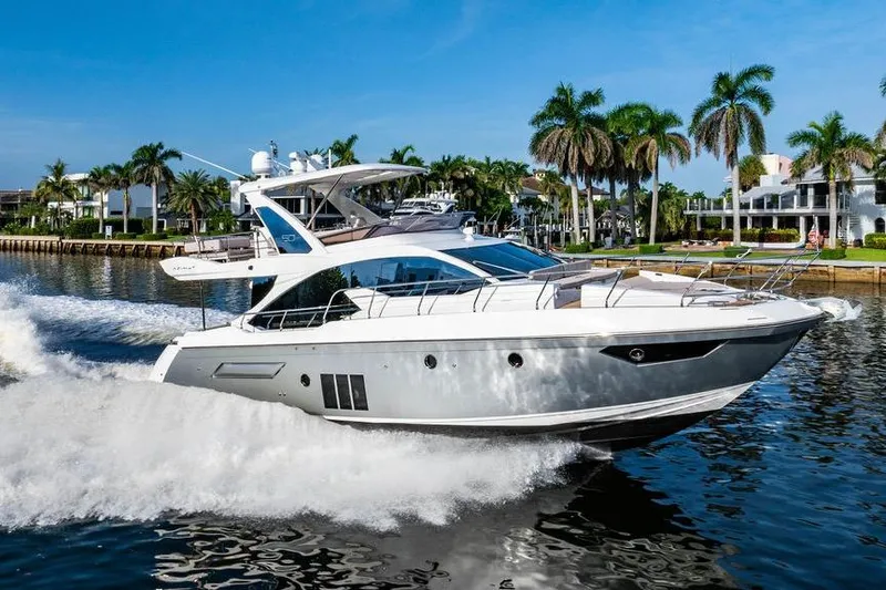 Slide: The Image of 2015 Azimut Fly 50 yacht cruising on a sunny day near palm-lined waterfront. - 36