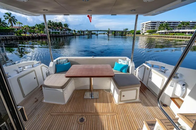 Slide: The Image of Luxurious 2015 Azimut Fly 50 yacht deck with seating, table, and scenic waterfront view. - 41