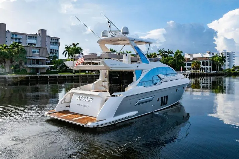 Slide: The Image of 2015 Azimut Fly 50 yacht cruising on a calm waterway near luxury waterfront homes. - 5