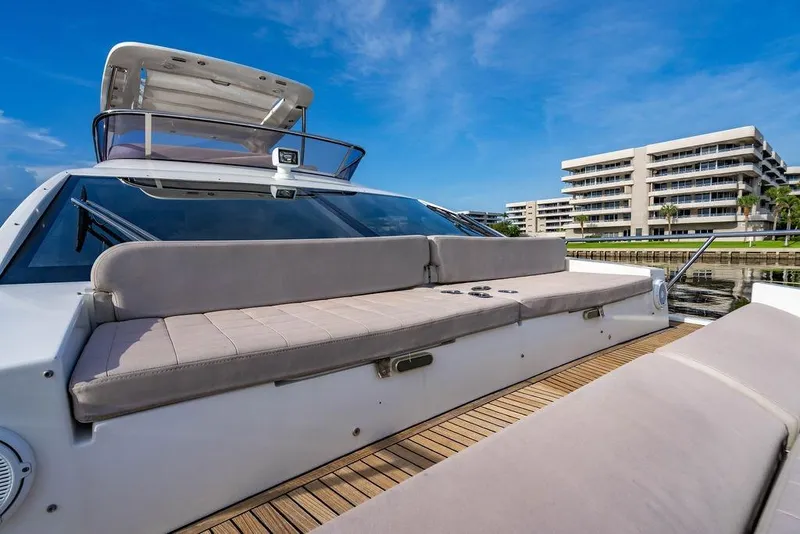Slide: The Image of 2015 Azimut Fly 50 yacht with spacious deck seating, docked near modern buildings. - 54