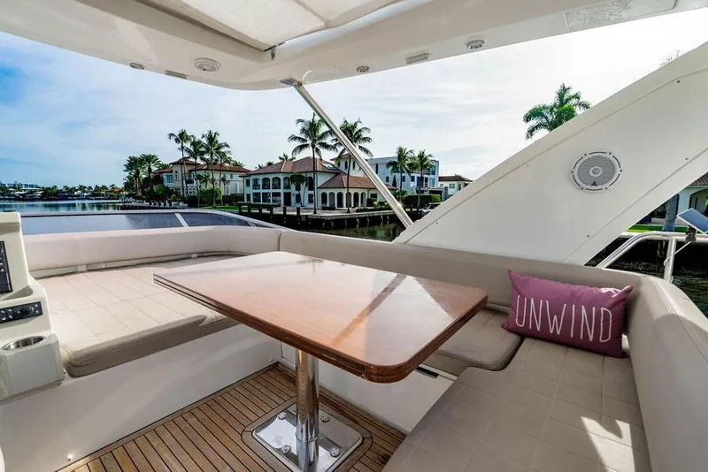 Slide: The Image of Luxurious 2015 Azimut Fly 50 yacht deck with seating, table, and "Unwind" pillow. - 76