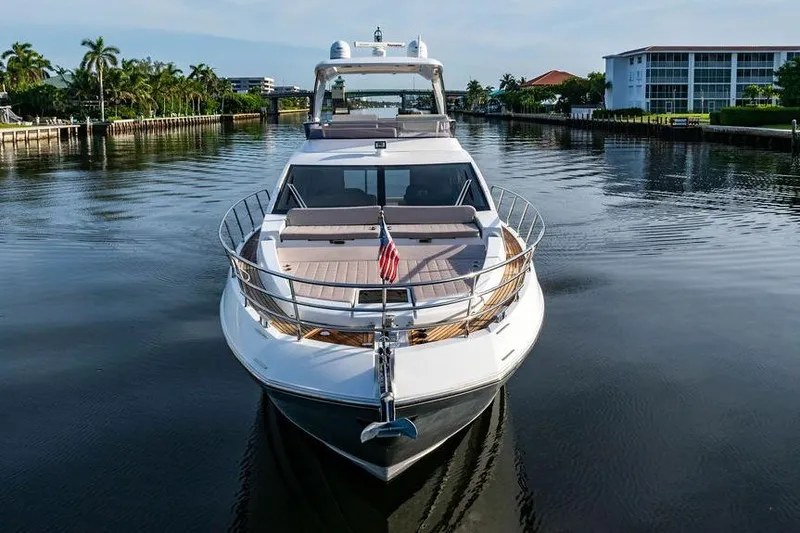 Slide: The Image of 2015 Azimut Fly 50 yacht on a calm waterway, surrounded by lush greenery and buildings. - 8